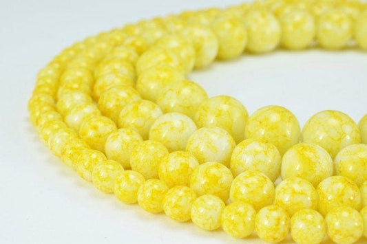 Yellow marble-style round beads, close-up, various sizes.