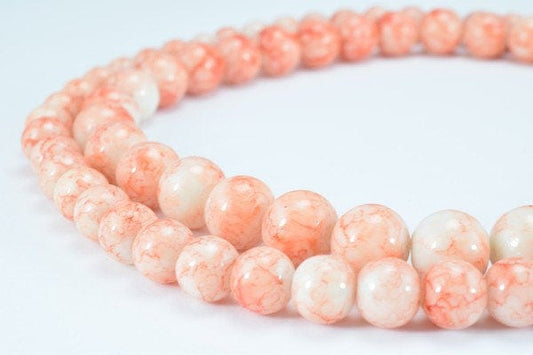 Pink and white marbled beads necklace on white background.