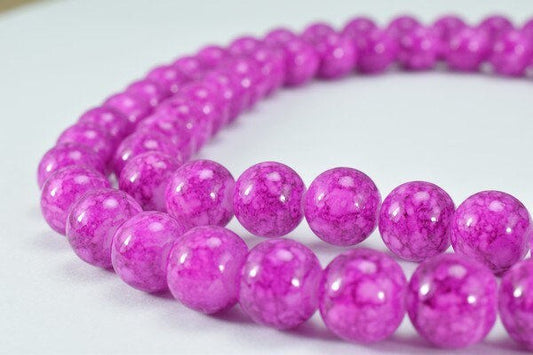 Pink agate bead necklace on white background.