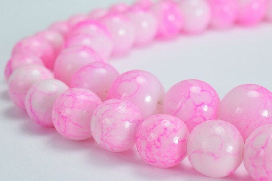 Pink marble bead necklace on white background.