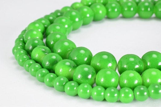 Green beaded necklace on white background.