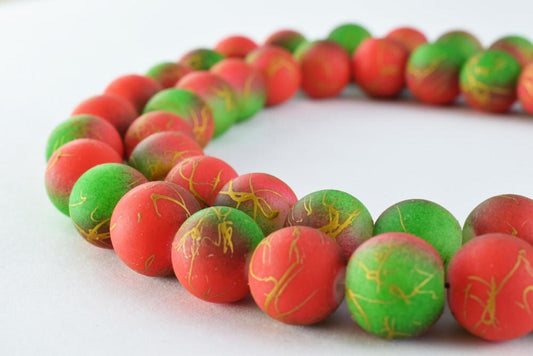 Colorful red and green marbled bead necklace on white background.