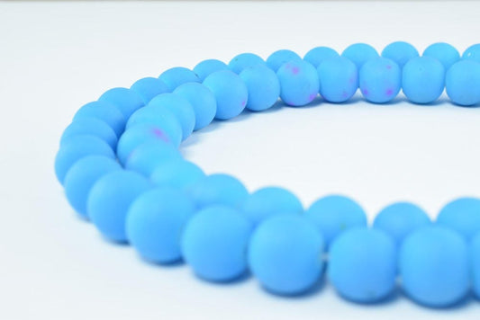 Blue silicone bead necklace close-up on white background.