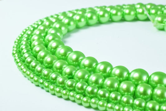 Green pearl beads in various sizes arranged in a strand.