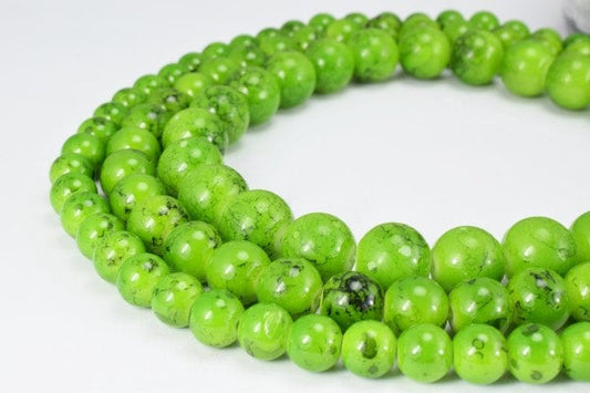 Green gemstone bead necklace strand on white background.