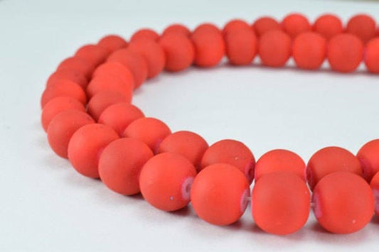 Red frosted glass bead necklace on white background.