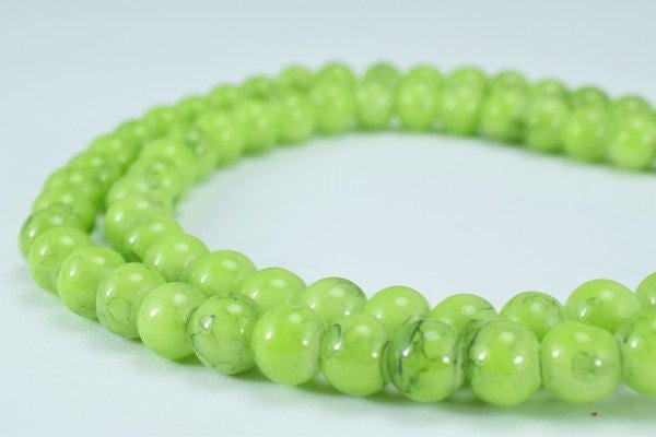 Green jade bead necklace on white background.