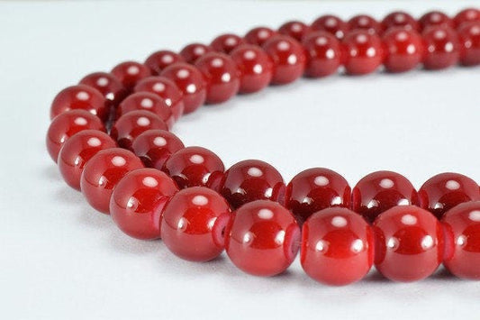 Red beaded necklace on white background.