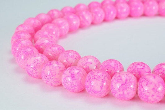 Pink marbled acrylic bead necklace on white background.