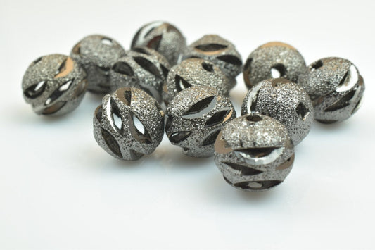 Textured silver metal beads on white background.