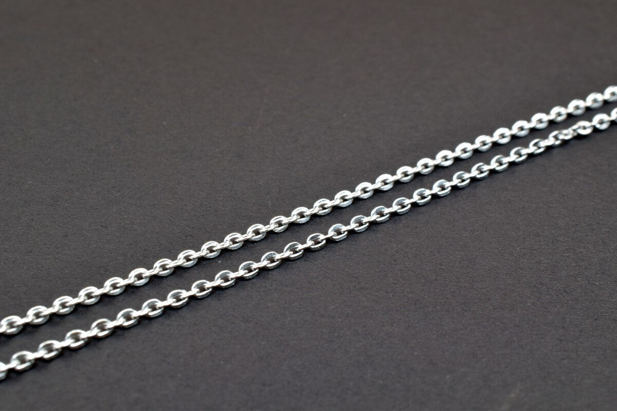 "Silver chain necklace on black background"