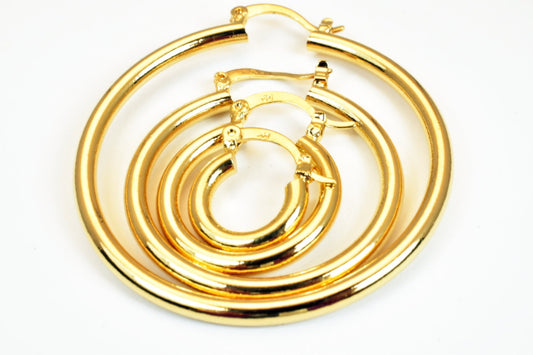 Gold hoop earrings set in varying sizes on white background.