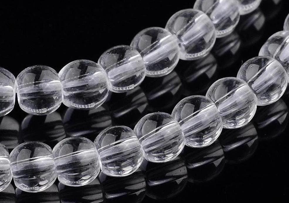 Clear crystal round beads on black background.