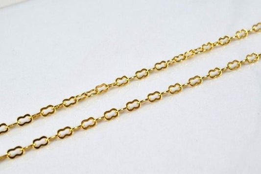 Gold clover chain necklace on white background.