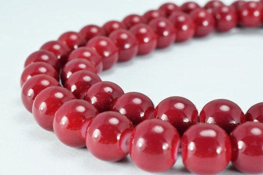 Red bead necklace close-up on light background.