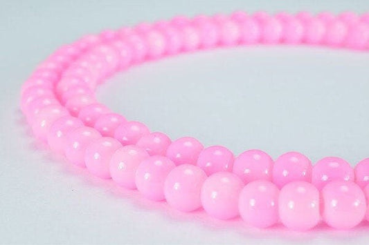 Pink beaded necklace close-up on light background.