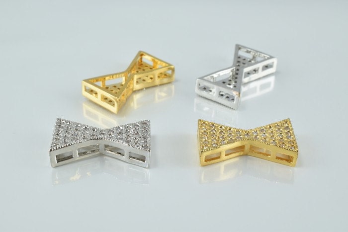 Gold and silver decorative bow-shaped jewelry connectors with rhinestone accents.